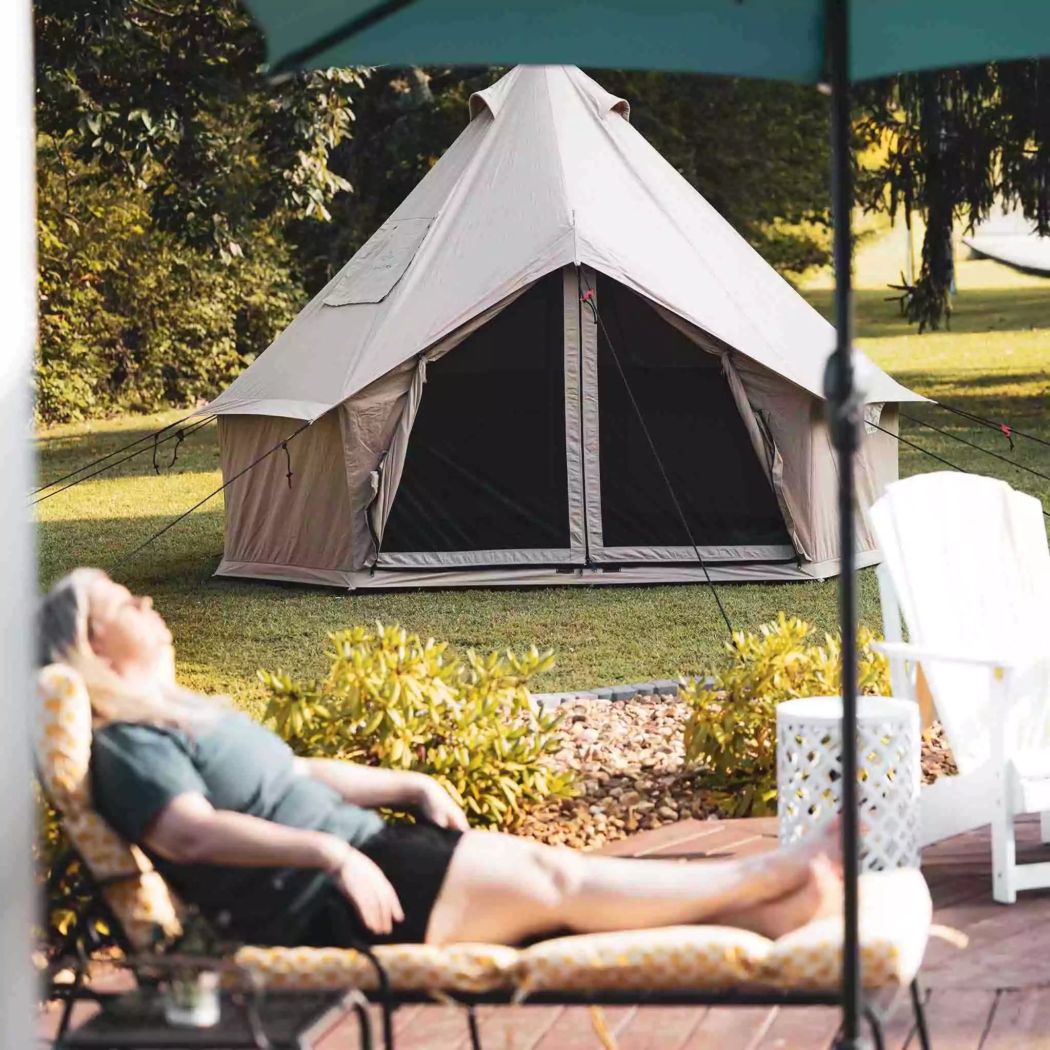 woman relaxing peacefully next to regatta bell tent