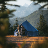 Regatta bell tent Sapphire Blue in forest with a man closing the front