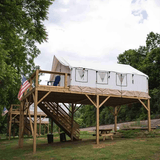 Alpha wall tent set up on a high platform perfectly fitting into the entire scene