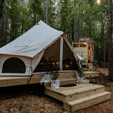 avalon bell tent set up on platform in the woods looking elegant