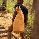 Hoplite Canvas Top Load Bag being carried up-hill by a man